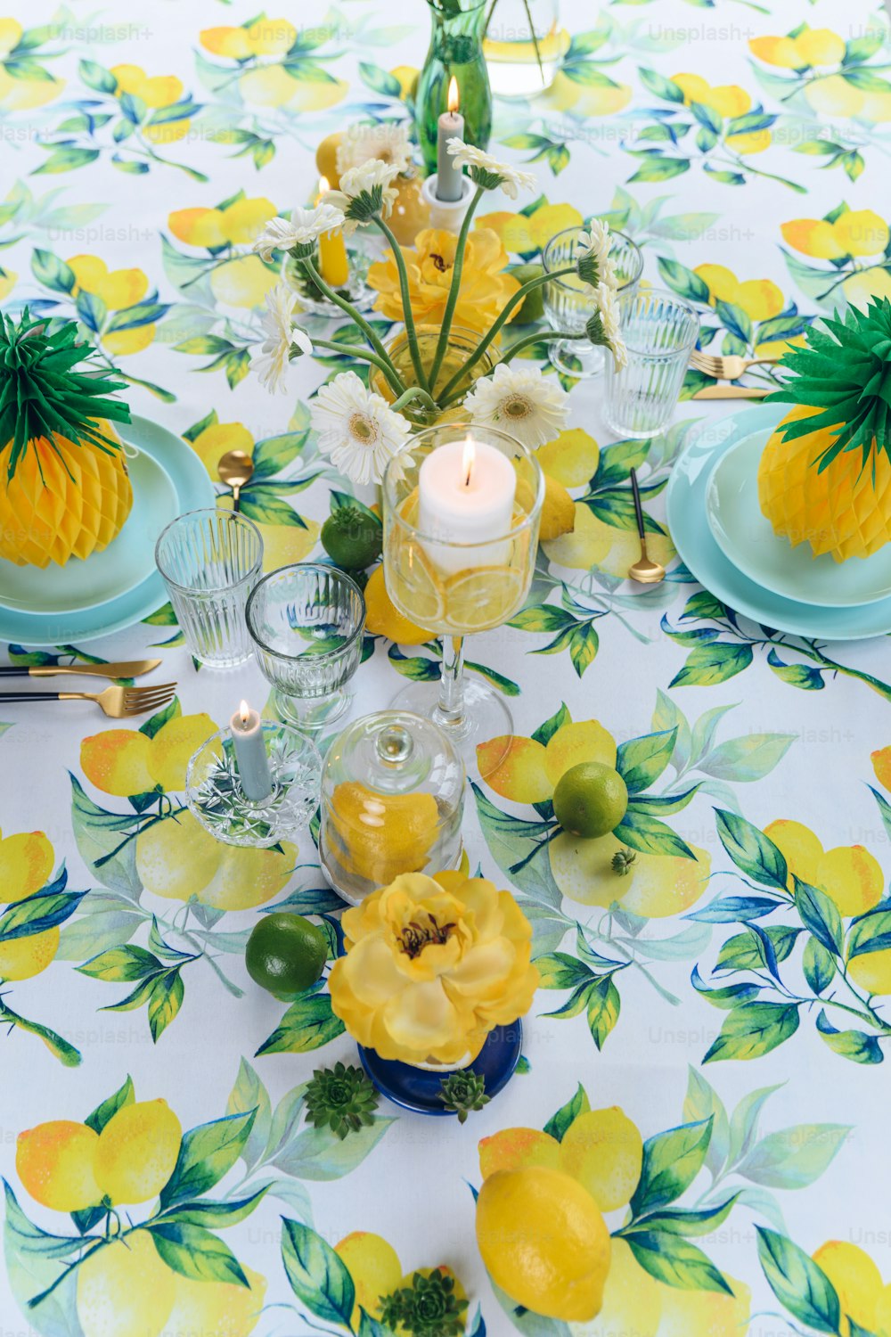 a table topped with yellow flowers and plates