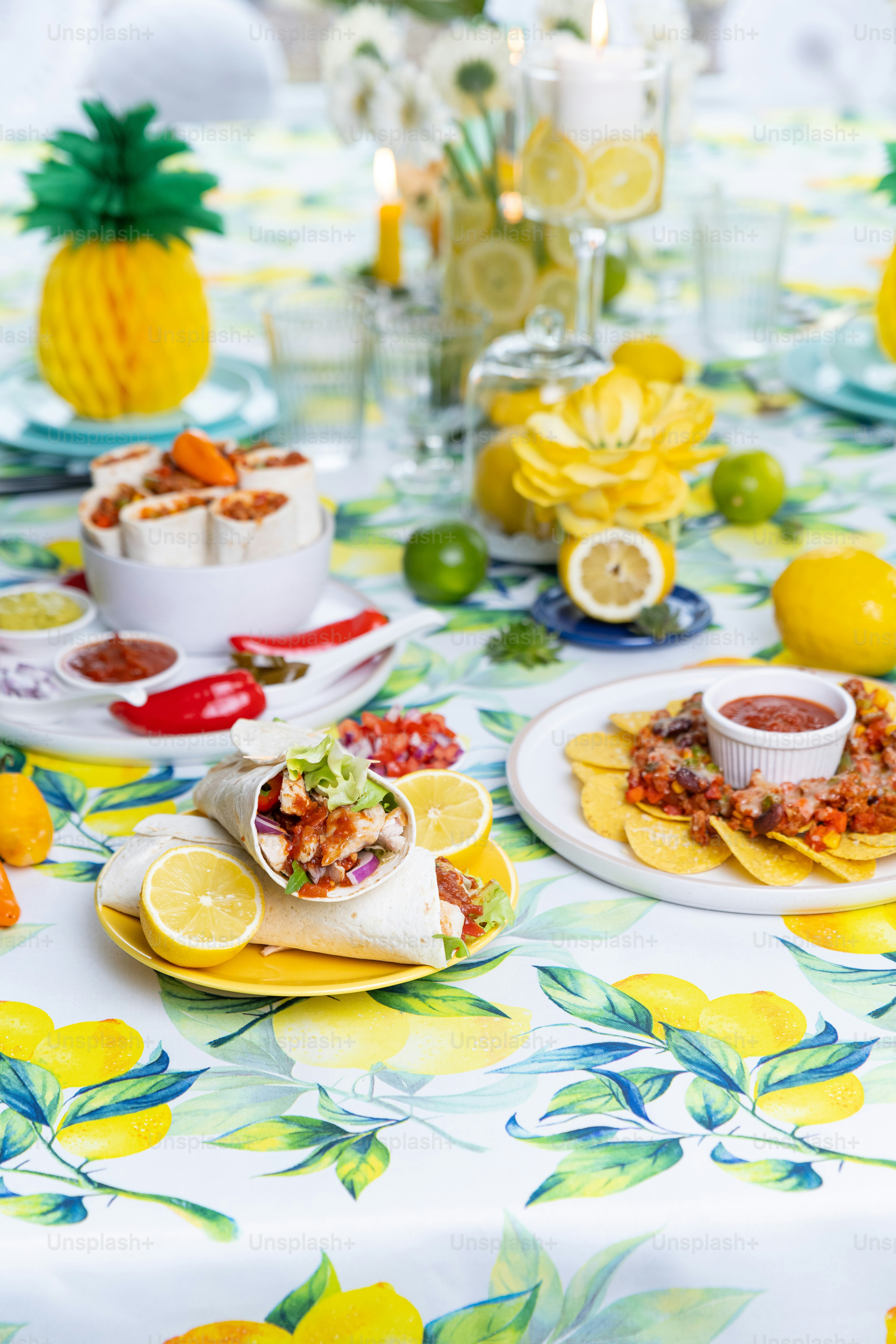 a table topped with plates of food next to lemons