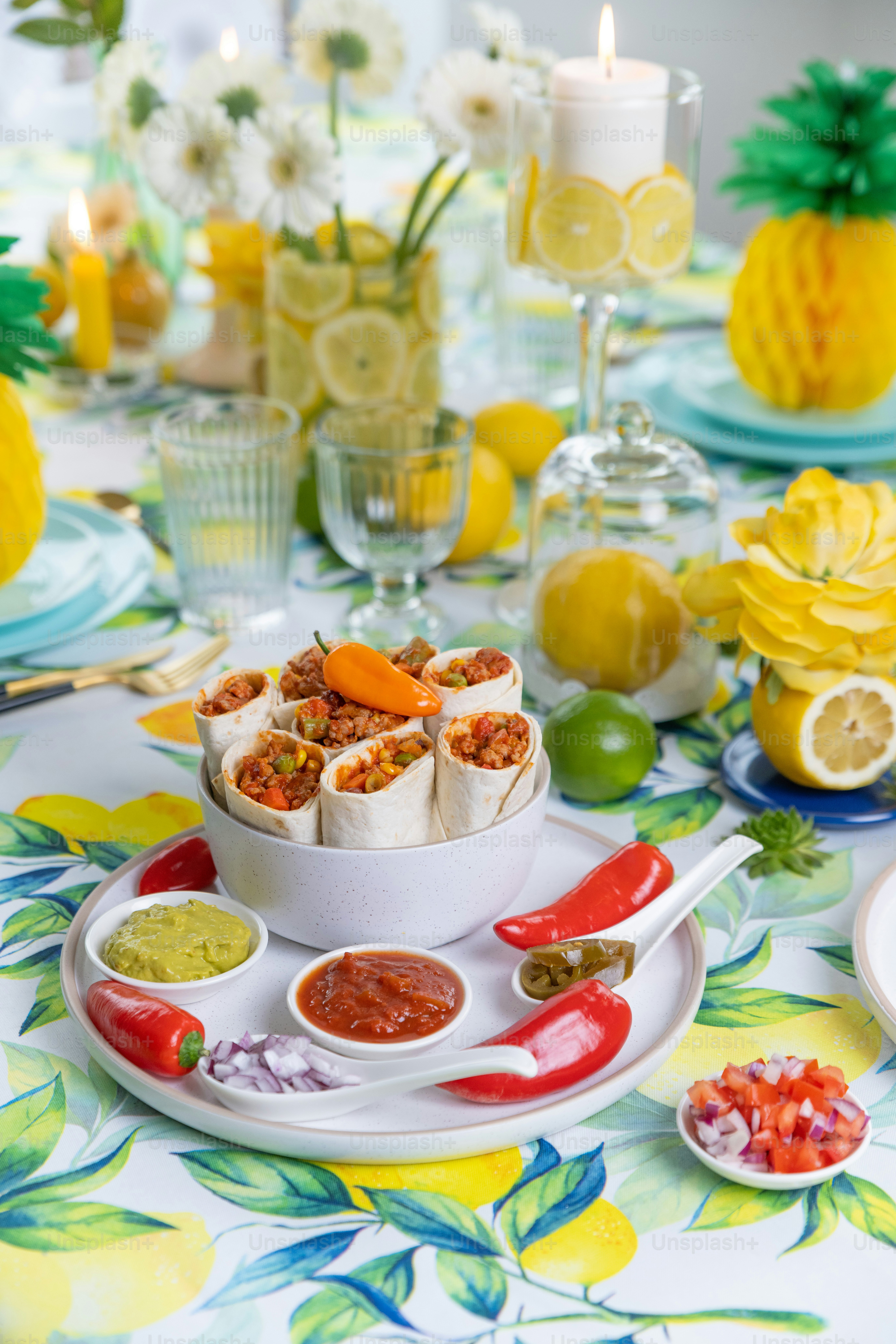 a table topped with a plate of food and a bowl of sauce