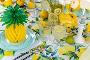 a table topped with plates and glasses filled with lemons