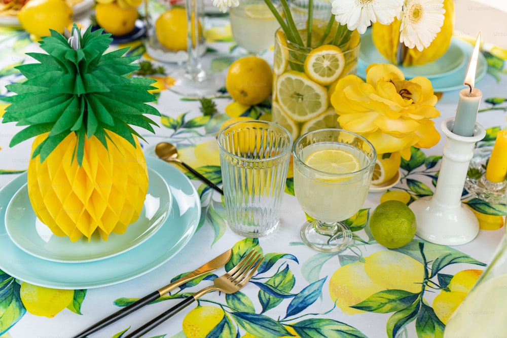 une table surmontée d’assiettes et de verres remplis de citrons