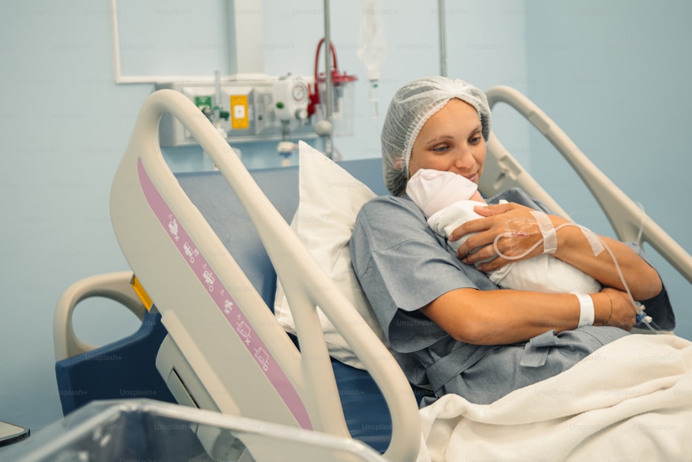 Una donna in un letto d'ospedale che tiene in braccio un bambino