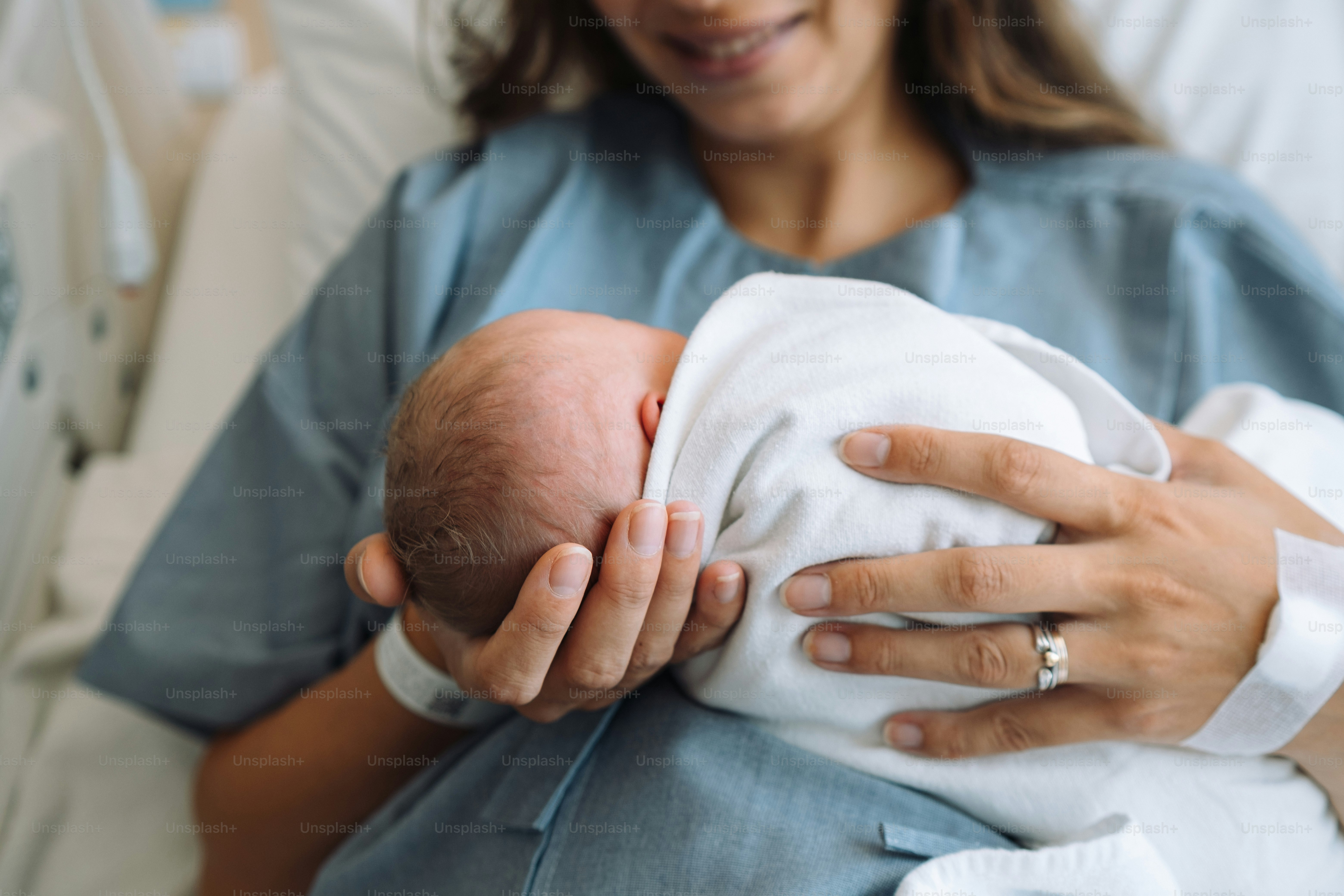 Una mujer sosteniendo a un bebé en una cama de hospital foto – Imagen ...