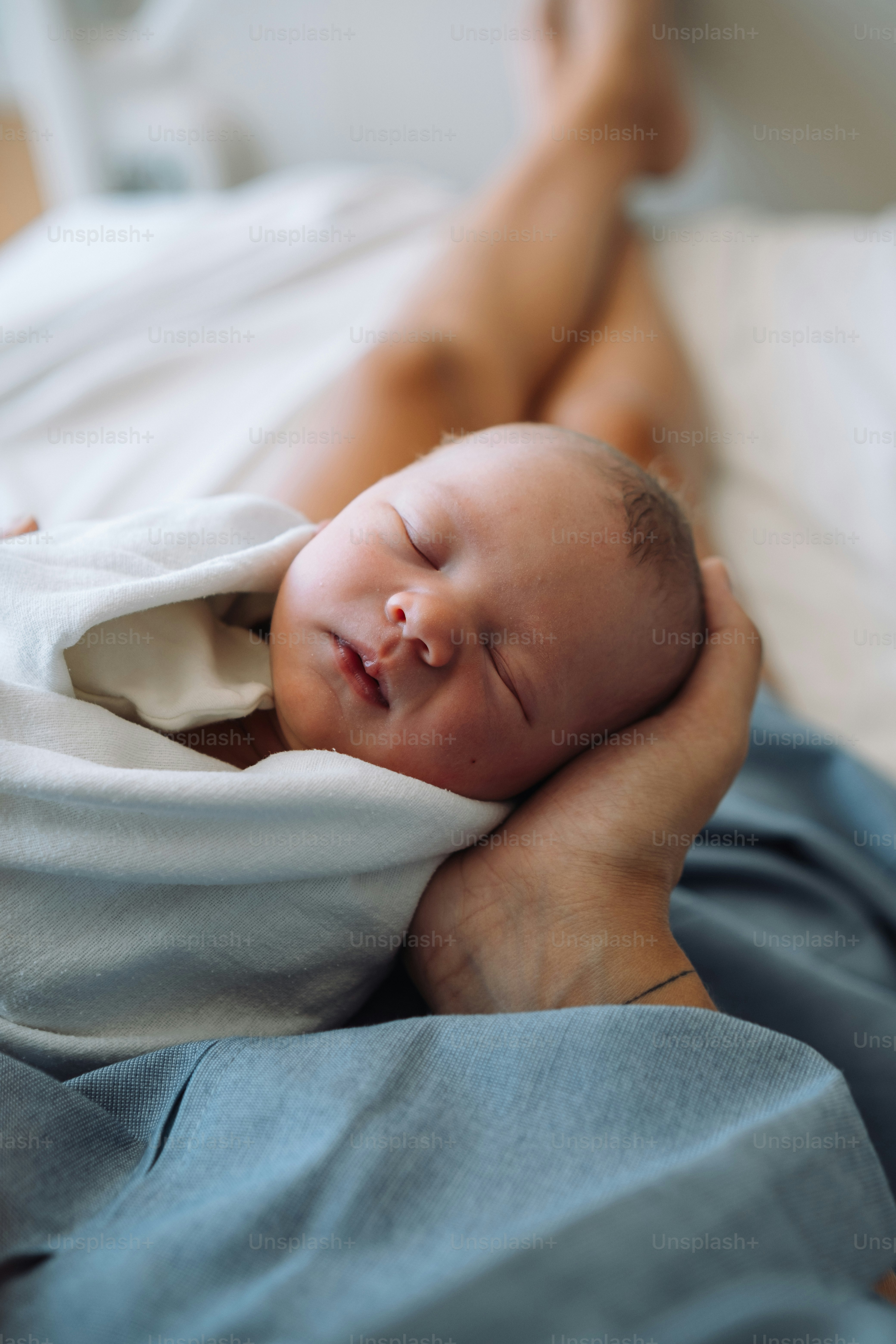 a person holding a baby wrapped in a blanket