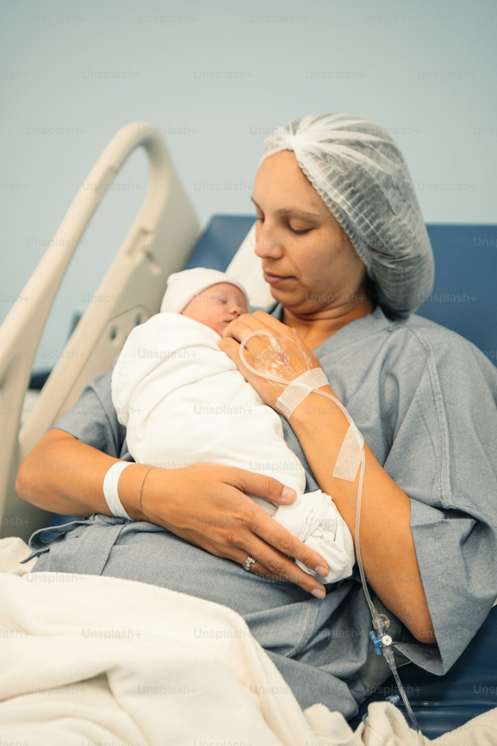 a woman holding a baby in a hospital bed