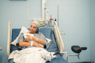 아기를 안고 병원 침대에 누워 있는 여자