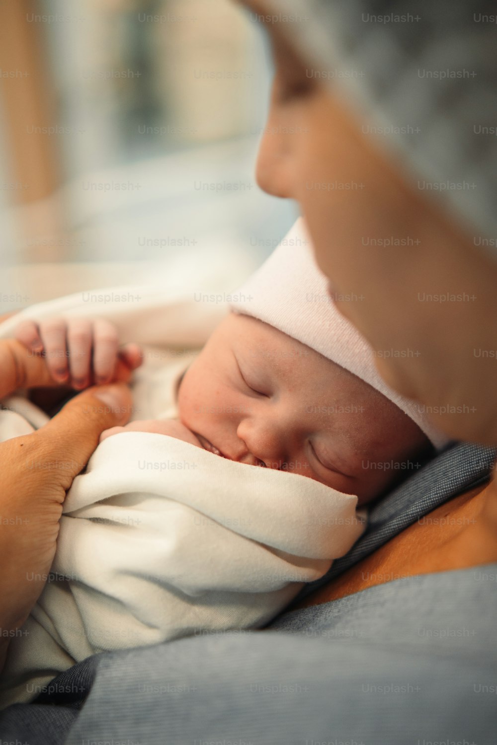 Eine Frau, die ein Baby hält, das in eine Decke gewickelt ist