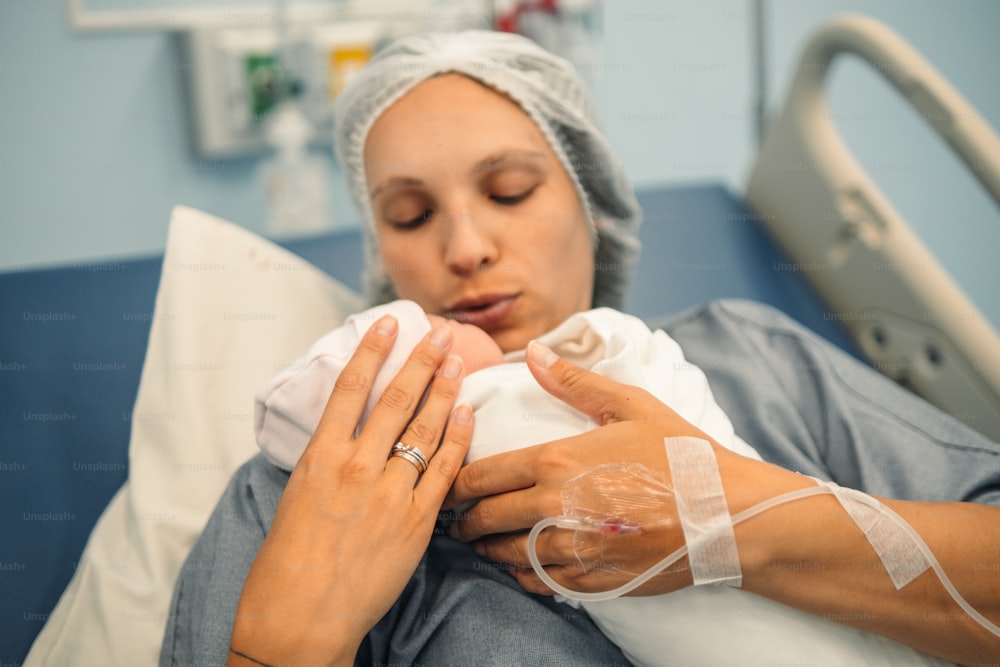 a woman holding a baby in a hospital bed