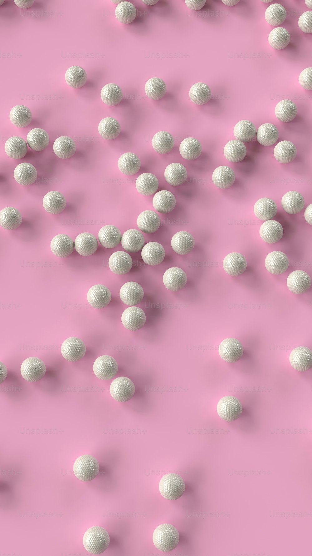a bunch of white balls floating on top of a pink surface