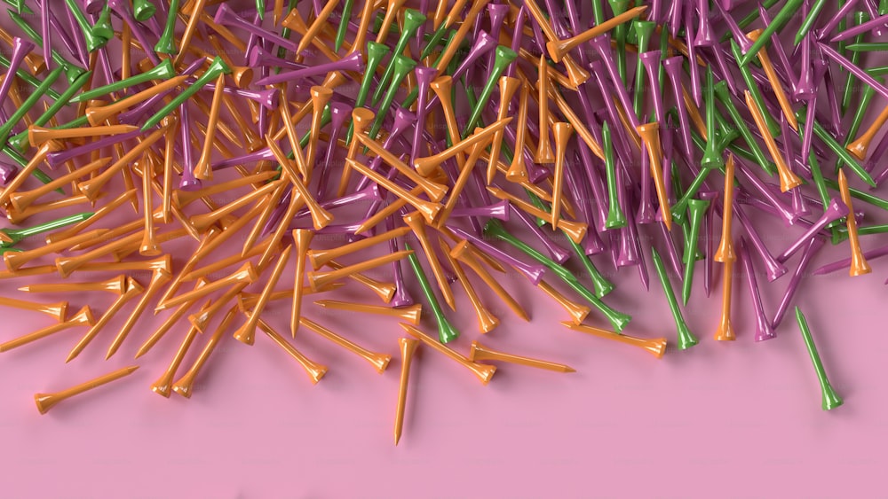 a pile of colorful toothpicks on a pink surface