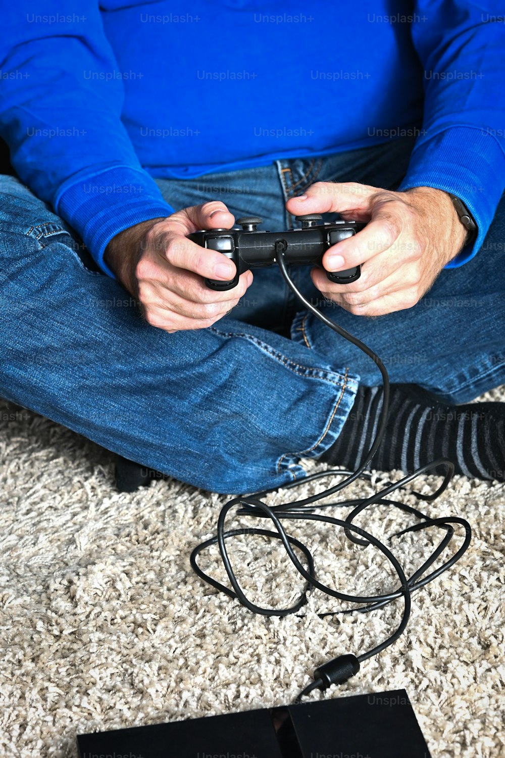 바닥에 앉아 비디오 게임을 하는 남자