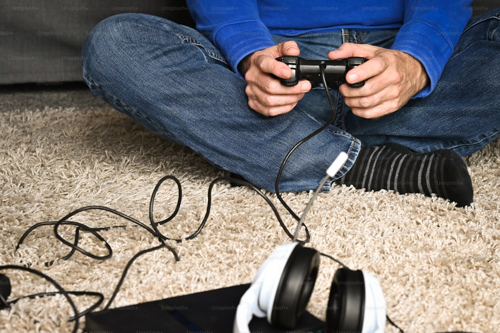 바닥에 앉아 비디오 게임을 하는 남자