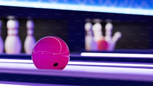 eine Kegelbahn mit rosa Bowlingkugeln und Bowlingkugeln