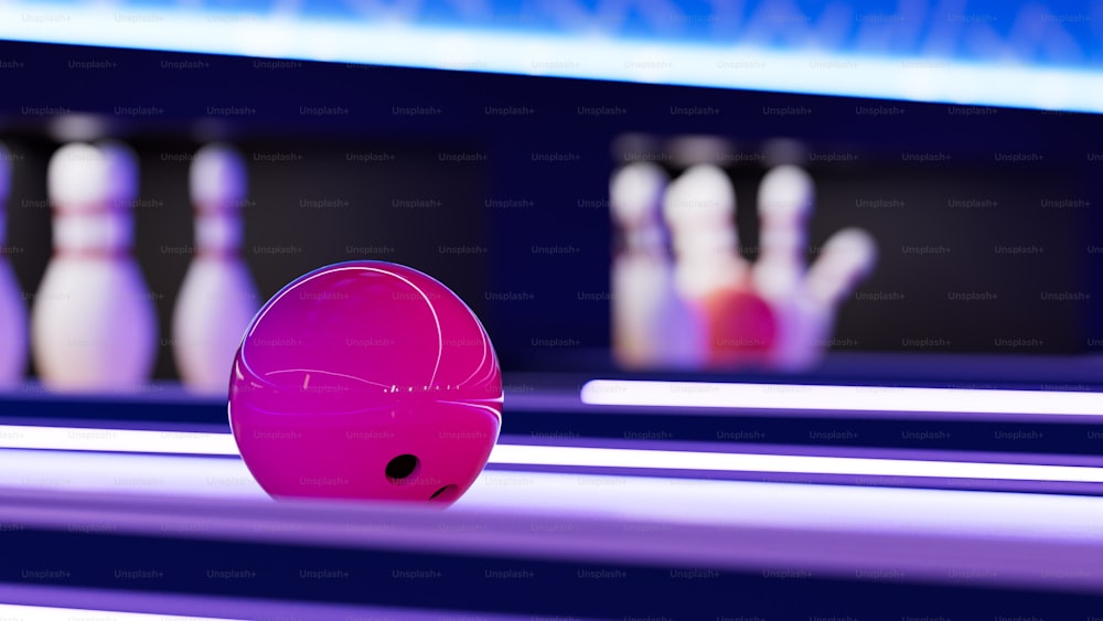 a bowling alley with pink bowling balls and bowling pins