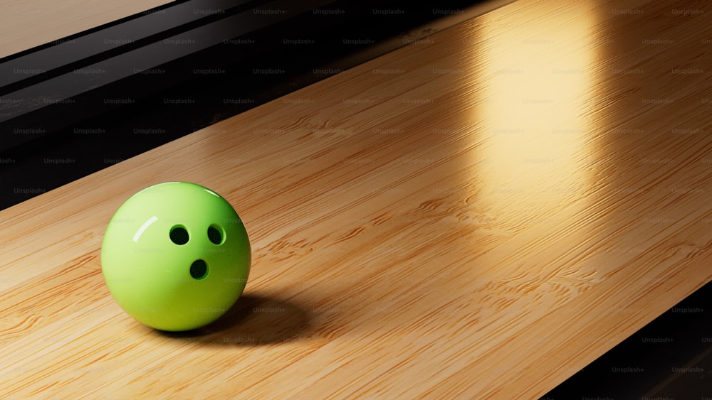 una palla da bowling verde seduta sopra un pavimento di legno