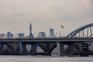 a bridge over a river with a city in the background