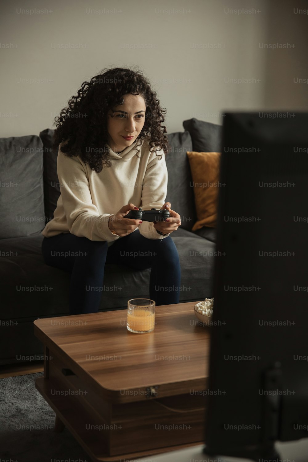 a woman sitting on a couch looking at her cell phone
