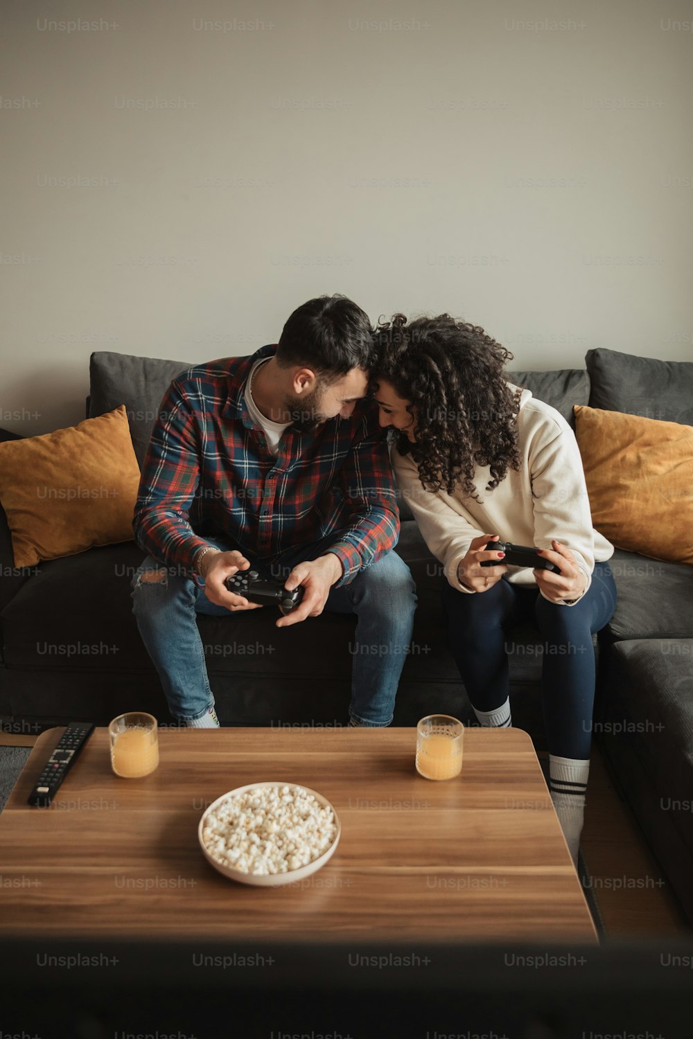 a man and woman sitting on a couch looking at a cell phone