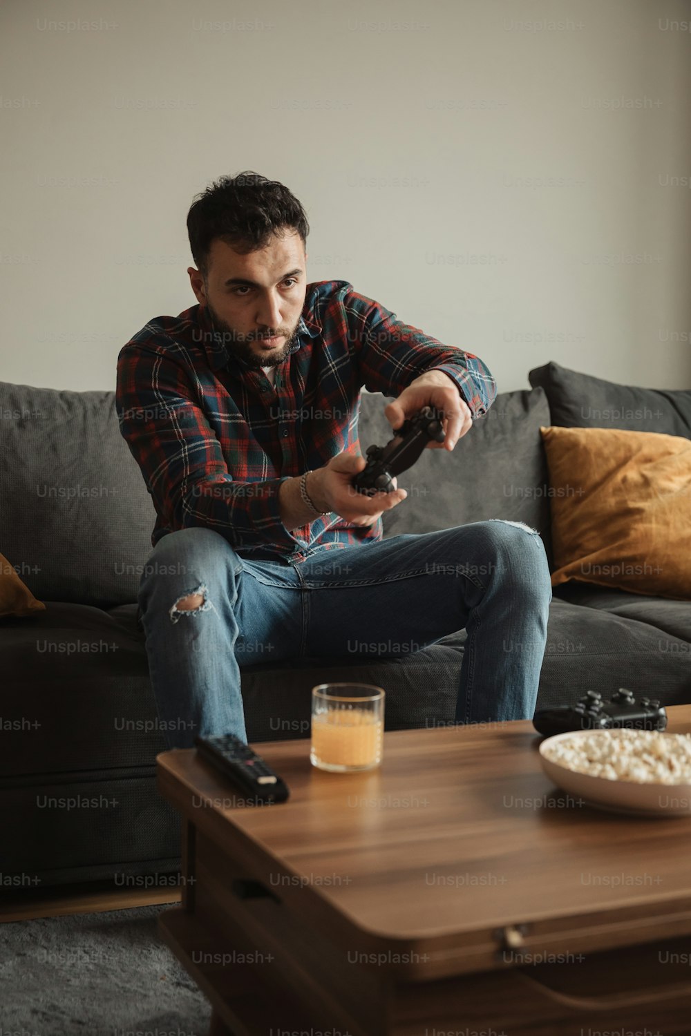 Un uomo seduto su un divano che tiene un telecomando