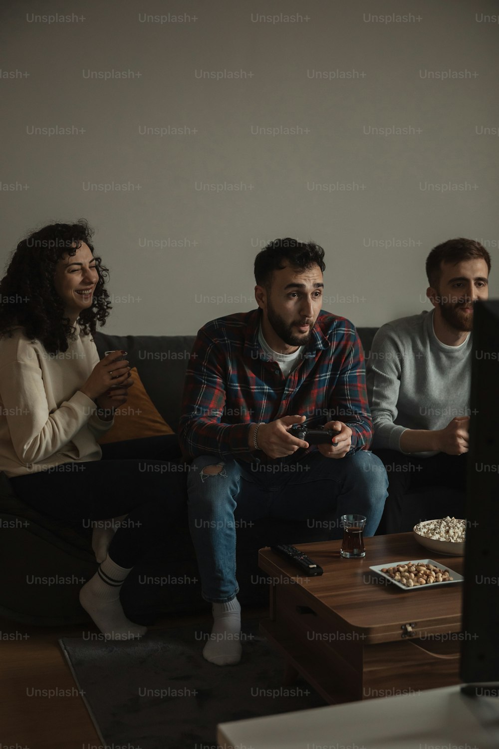 a group of people sitting on a couch watching tv