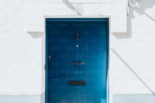 Une porte bleue est ouverte sur un bâtiment blanc