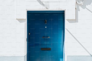 a blue door is open on a white building