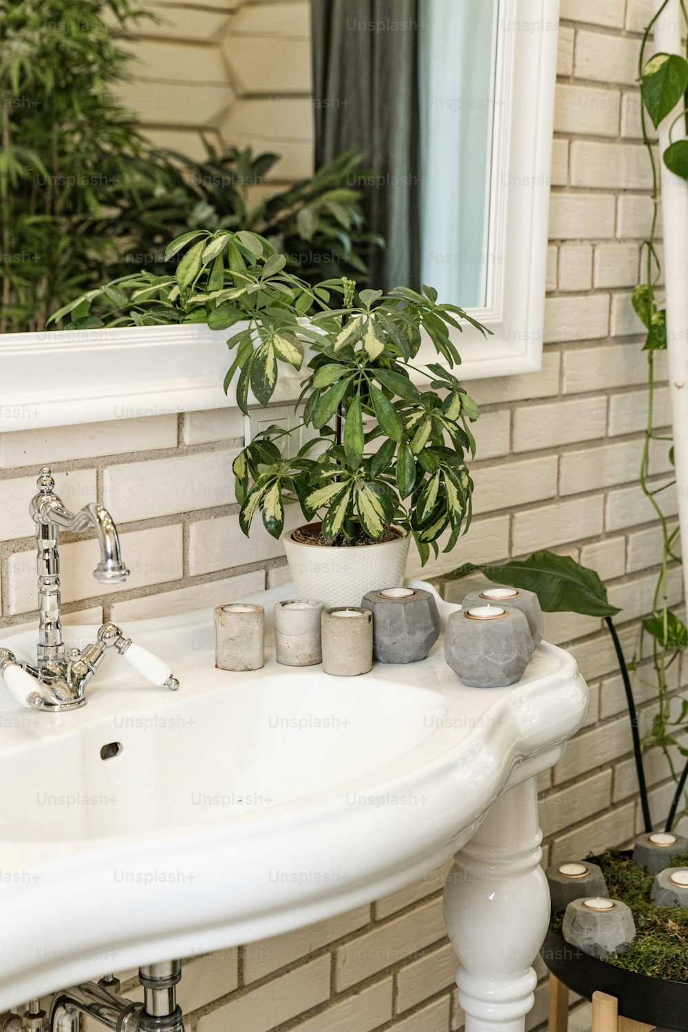 a white sink sitting under a mirror next to a window