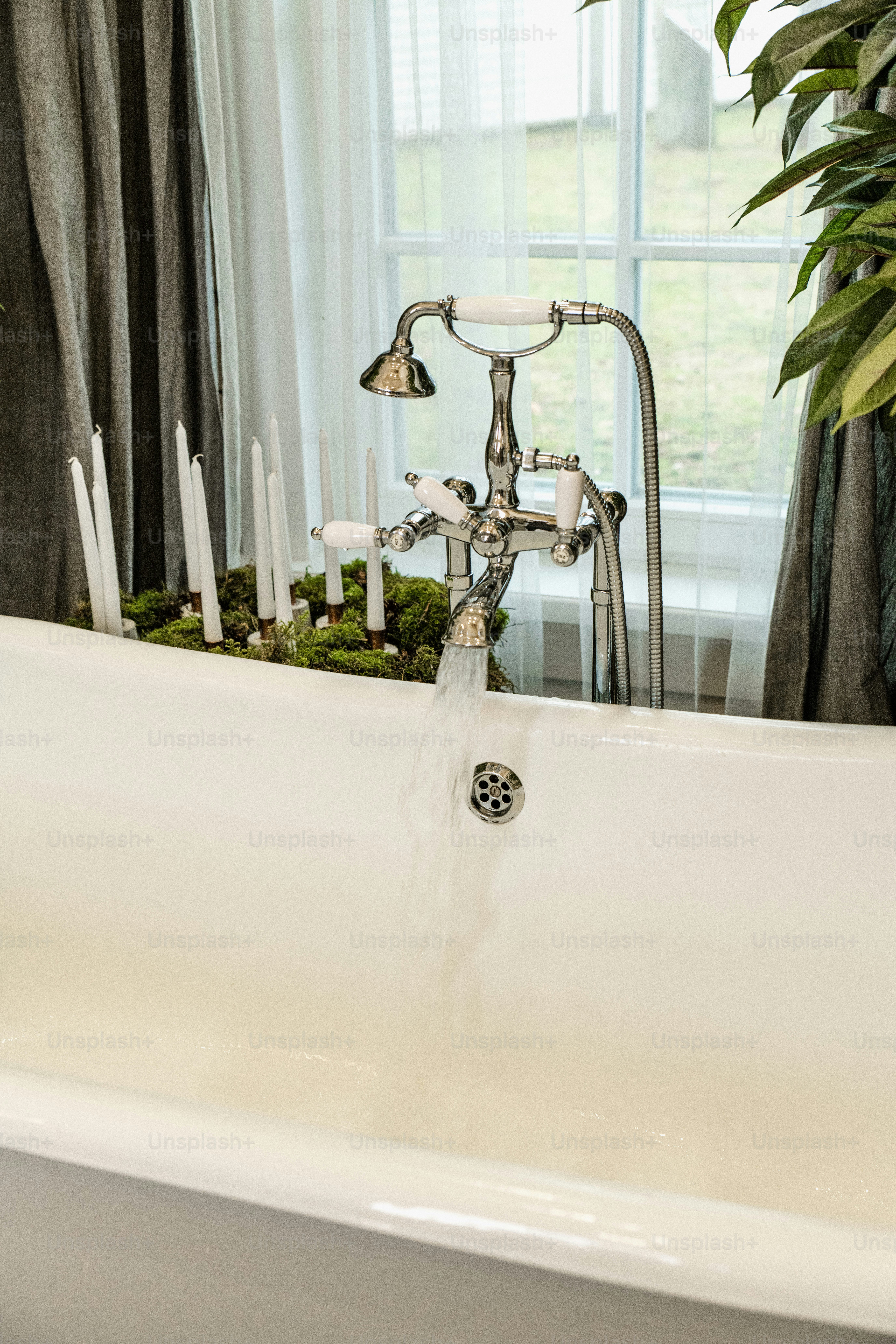 A white bath tub with a faucet running water photo Tap water Image on
