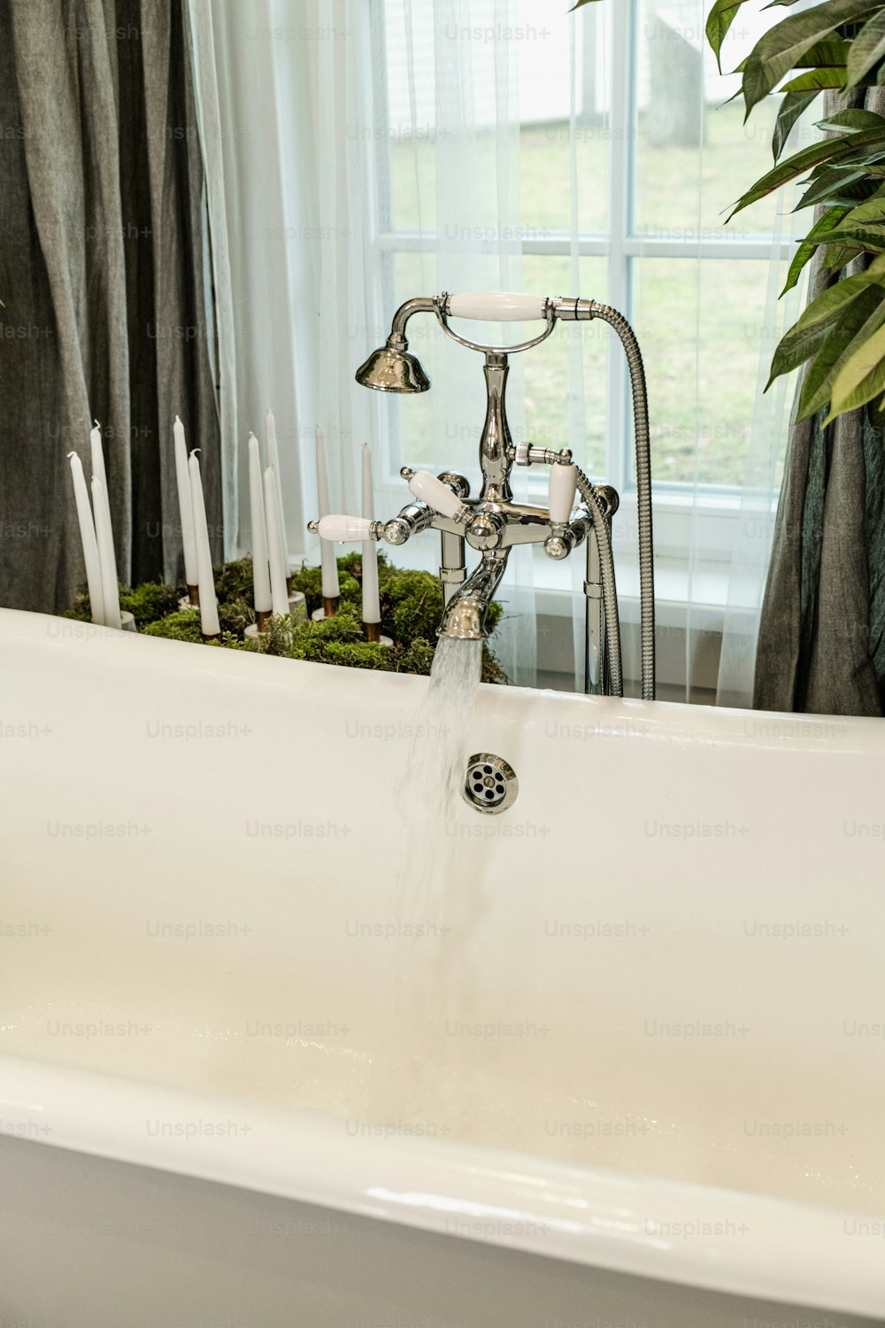 a white bath tub with a faucet running water