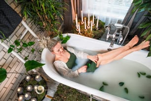 a woman laying in a bathtub with her feet in the water