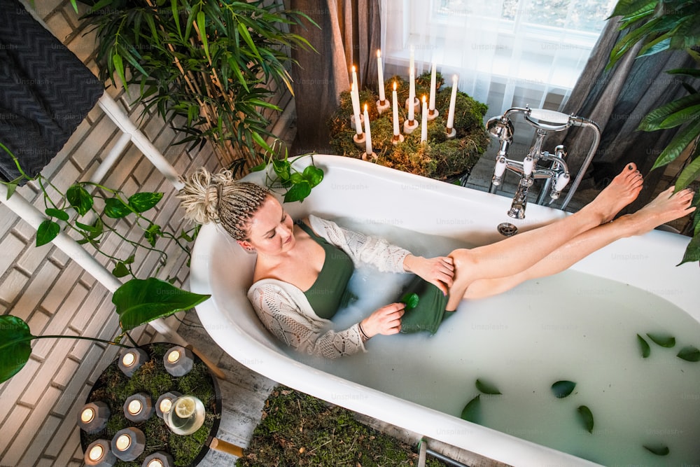 Una donna sdraiata in una vasca da bagno con i piedi nell'acqua