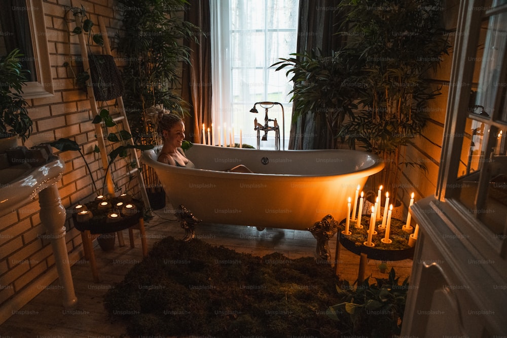 Eine Frau, die in einer Badewanne sitzt, umgeben von Kerzen