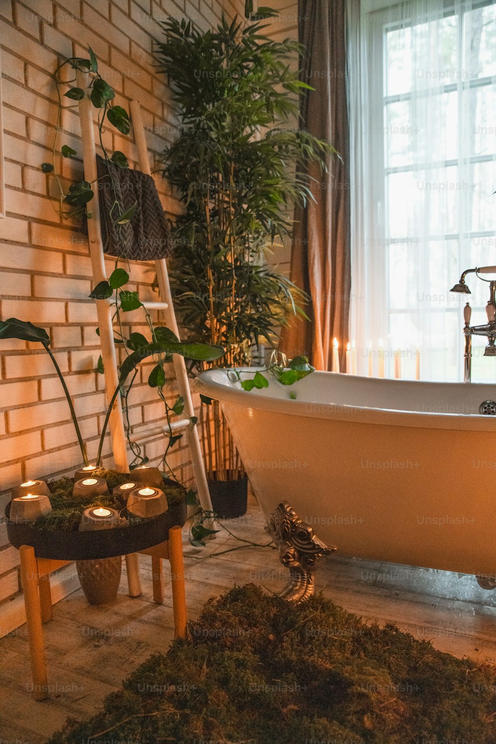 A bathroom with a claw foot tub and candles photo – Plants Image on Unsplash