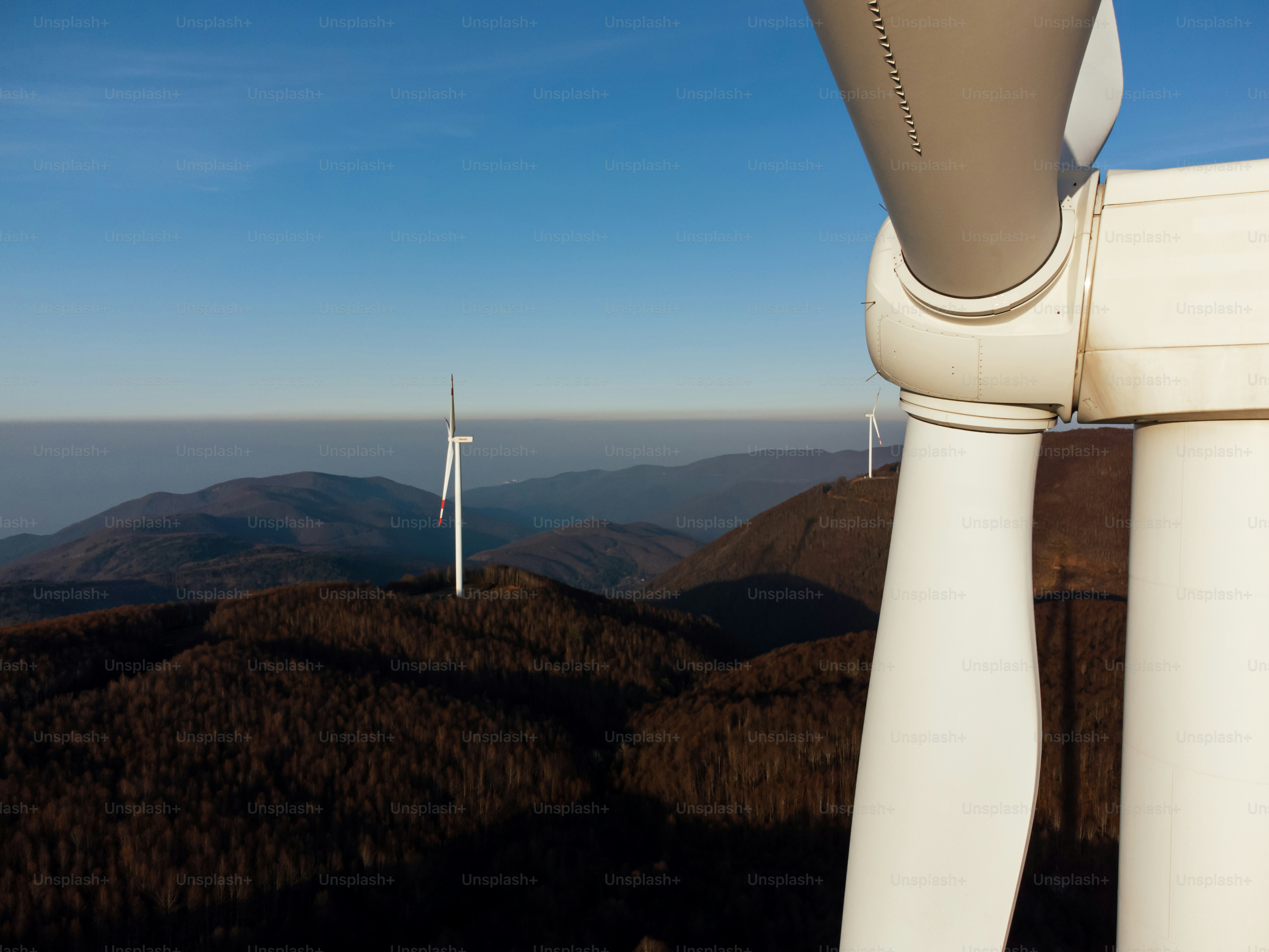 A group of wind turbines on top of a hill photo – Blue sky Image on ...