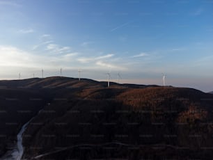 a group of wind turbines on a hill