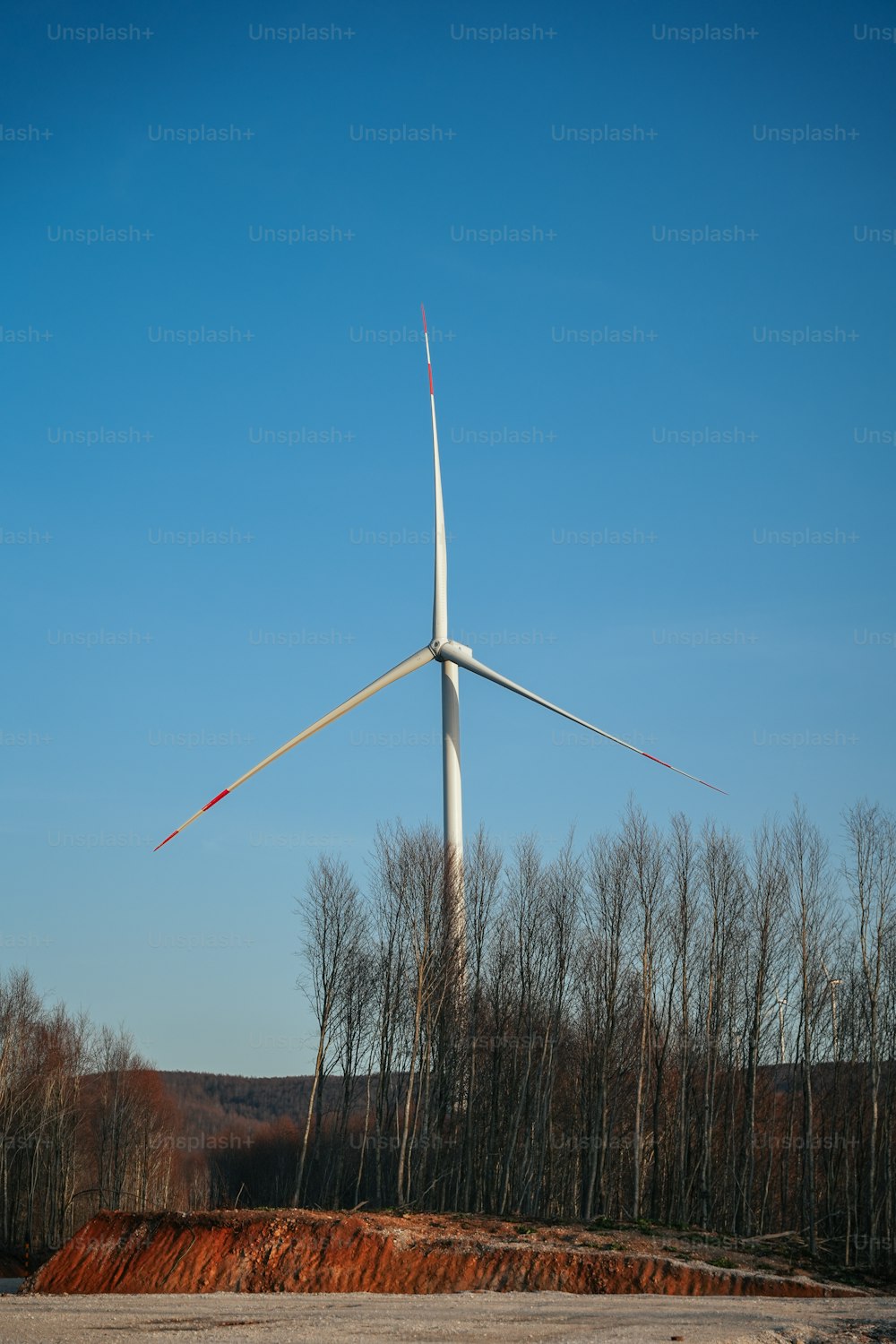a wind turbine on top of a dirt hill
