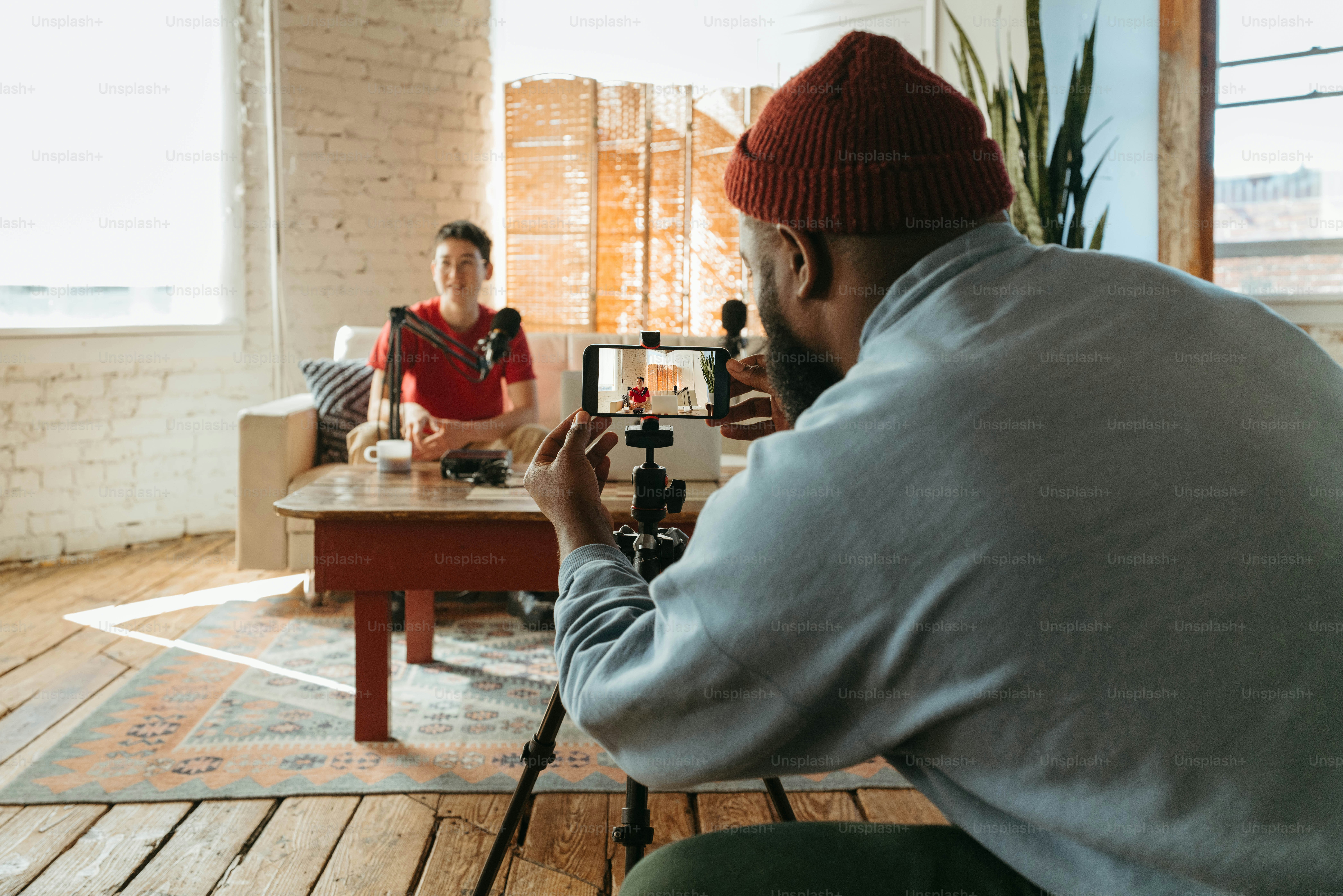 a man taking a picture of another man sitting at a table