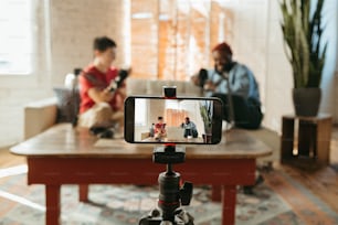 a person taking a picture of two people sitting on a couch