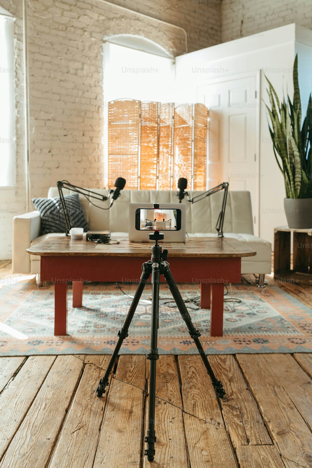 a living room with a couch and a tripod