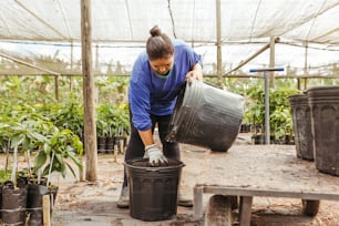 a woman in a blue shirt is holding a bucket