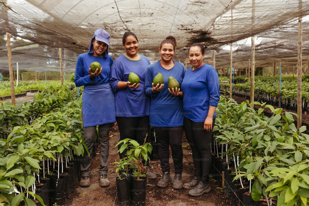 a group of women standing next to each other in a greenhouse