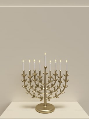 a golden menorah with lit candles on a table