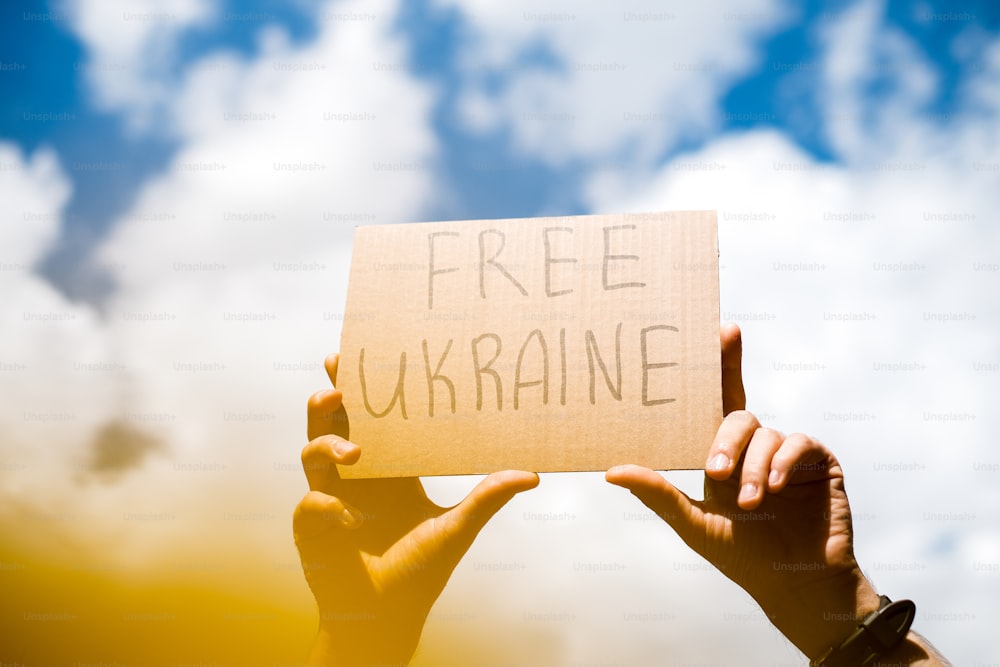 Eine Person, die ein Schild mit der Aufschrift "Freie Ukraine" hochhält