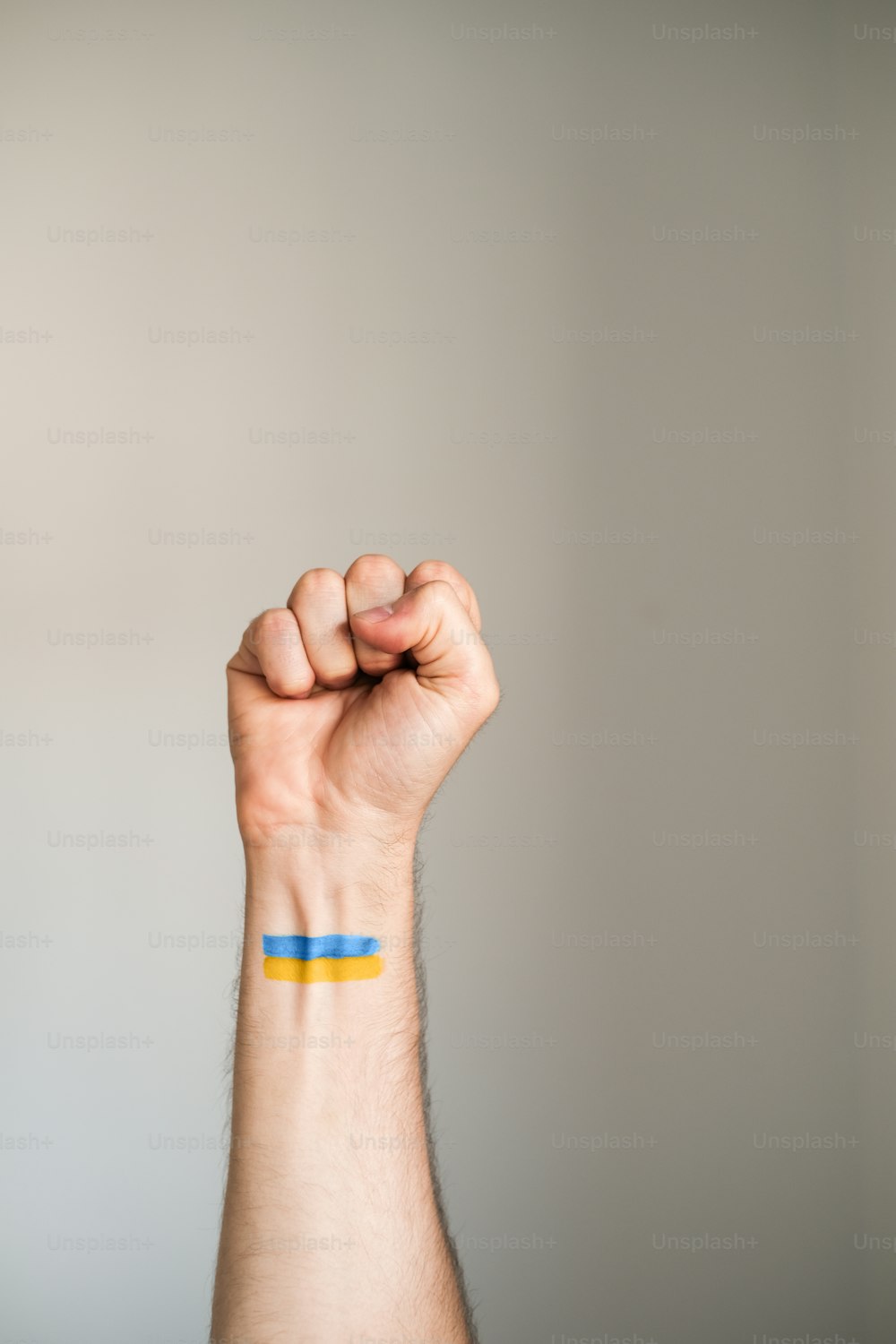 o braço de um homem com uma faixa azul e amarela sobre ele