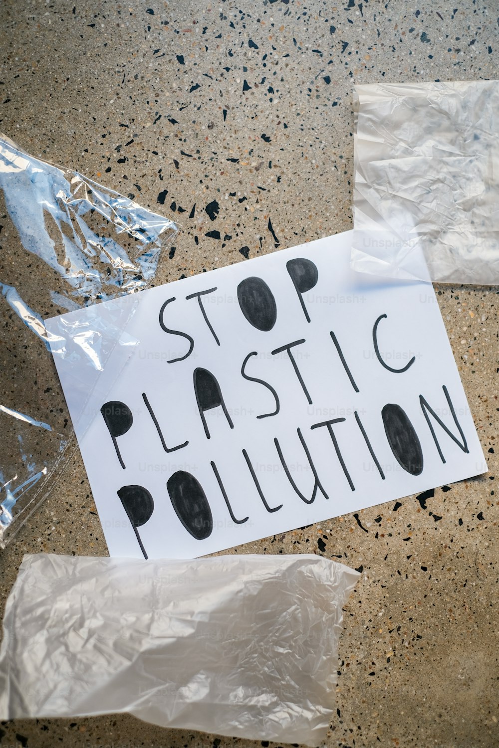 Ein Schild mit der Aufschrift "Stoppt die Plastikverschmutzung auf dem Boden"