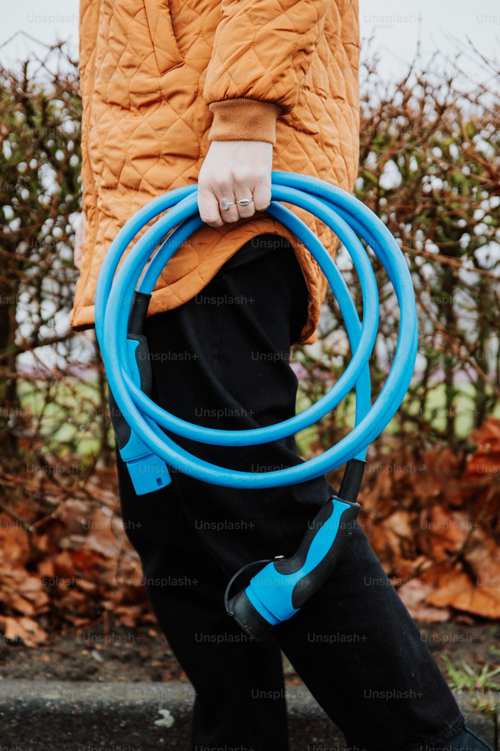a person holding a blue hose in their hands