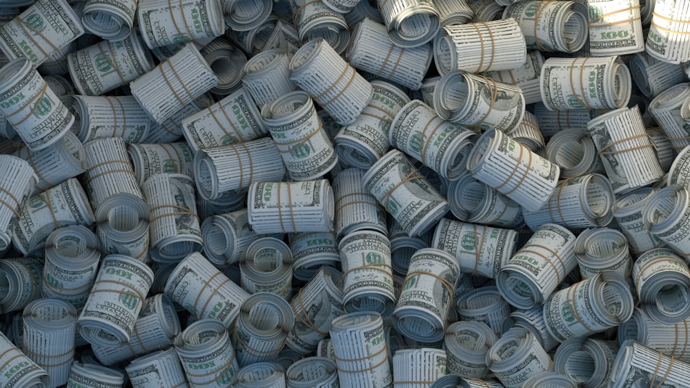 a pile of rolled up dollar bills sitting on top of each other