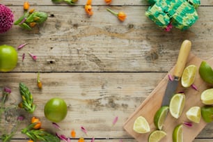 a cutting board with limes and flowers on it