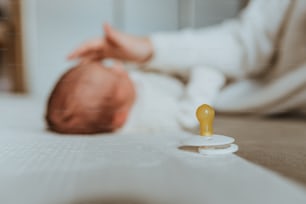 a pacifier sitting on top of a bed next to a baby