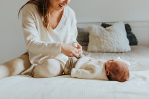 a woman sitting on a bed holding a baby